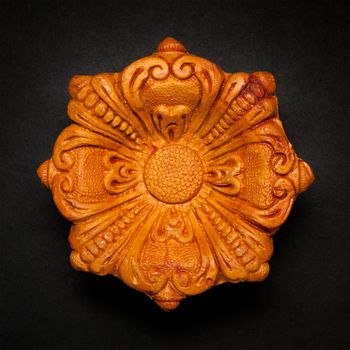 Top view of a beautifully carved designer handmade clay lamp on dark background.