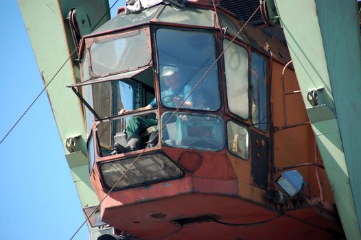Dockside cargo crane operator at river port Kolyma, Yakutia, Russia