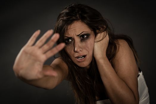 Young abused woman defending with pray looking and outstretched arm. 