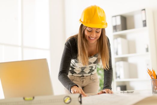 Smiling young architect working in her office.