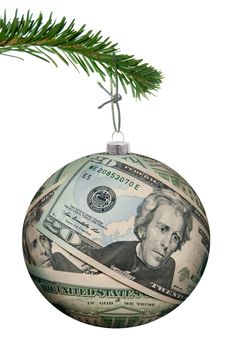 Christmas bauble made of dollar banknotes hanging from a tree 