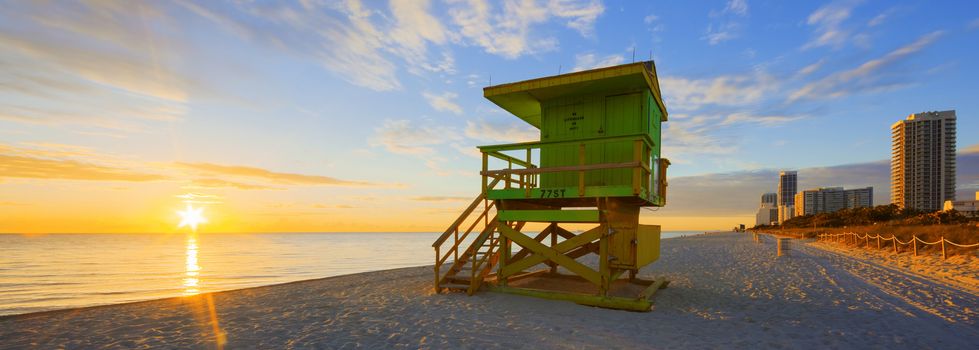 Miami South Beach sunrise with lifeguard tower and coastline with colorful cloud and blue sky. 