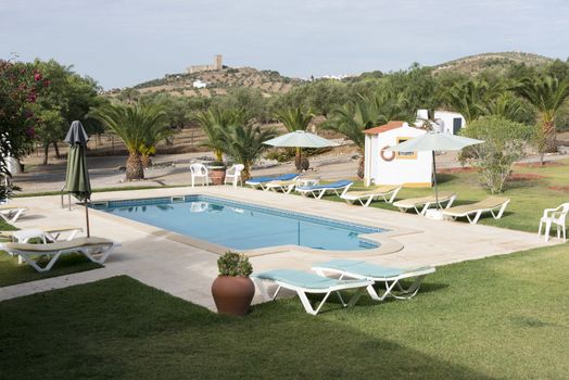garden with swimming pool in portel portugal with the castle on the mopuntain top