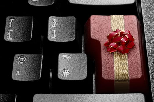 Computer enter key wrapped with decorative bow and red ribbon 