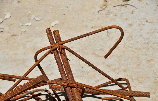 Rusty corroded stained metal pieces of wire, fitting, armature on a dirty concrete floor