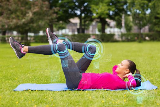 fitness, sport, training, park and lifestyle concept - smiling woman doing exercises on mat outdoors