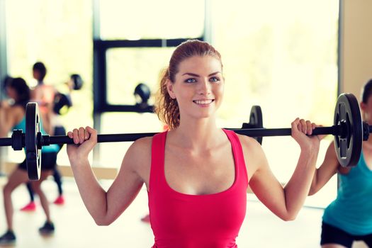 fitness, sport, training and lifestyle concept - group of women with barbells in gym