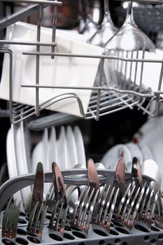 Open dishwasher with clean utensils