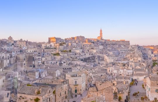 panoramic view of typical stones and church of Matera and the Madonna de Idris under begin sunset sky. Basilicata, Italy