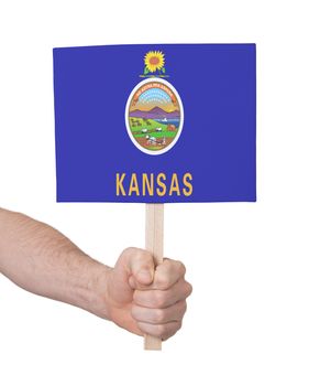 Hand holding small card, isolated on white - Flag of Kansas