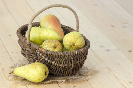 Juicy fresh pears in a basket wooden background