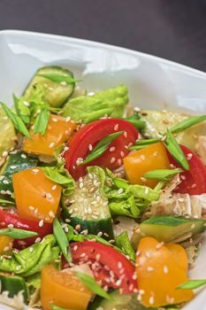 Bulgarian salad from pepper, cucumbers, tomato, green onion with sesame and oil