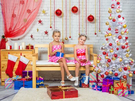 Two funny sisters four girls and six years of playing and having fun in the home New Years interior