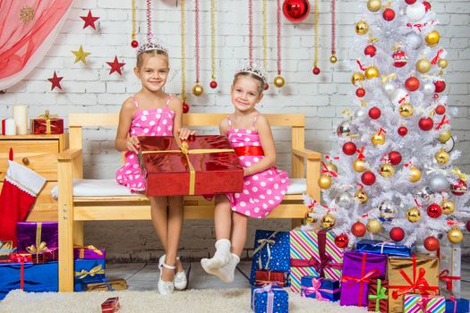 Two funny sisters four girls and six years of playing and having fun in the home New Years interior