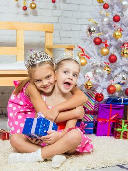 Two funny sisters four girls and six years of playing and having fun in the home New Years interior