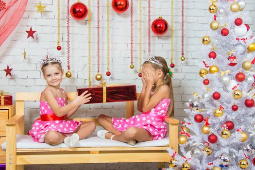 Two funny sisters four girls and six years of playing and having fun in the home New Years interior