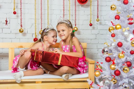 Two funny sisters four girls and six years of playing and having fun in the home New Years interior
