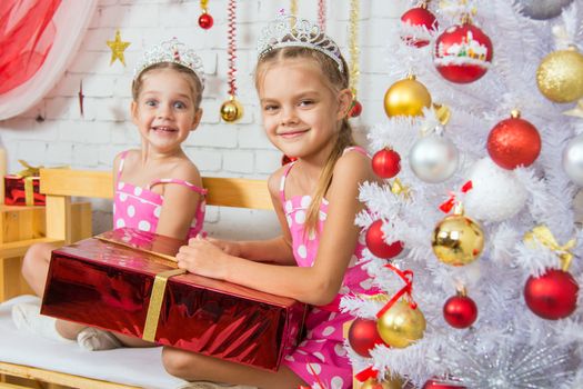 Two funny sisters four girls and six years of playing and having fun in the home New Years interior