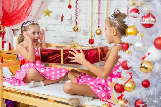Two funny sisters four girls and six years of playing and having fun in the home New Years interior
