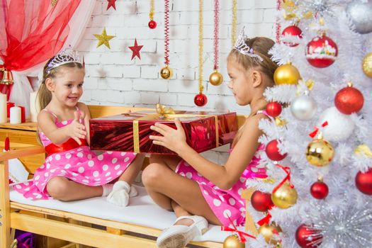 Two funny sisters four girls and six years of playing and having fun in the home New Years interior
