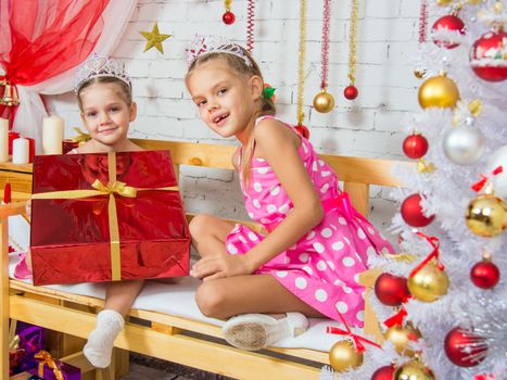 Two funny sisters four girls and six years of playing and having fun in the home New Years interior