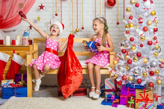 Two funny sisters four girls and six years of playing and having fun in the home New Years interior