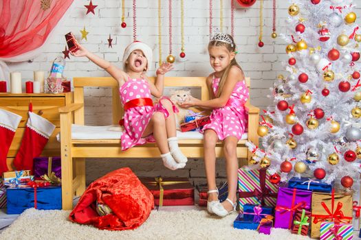 Two funny sisters four girls and six years of playing and having fun in the home New Years interior