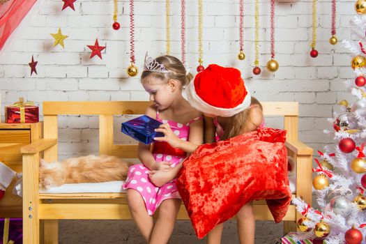 Two funny sisters four girls and six years of playing and having fun in the home New Year's interior