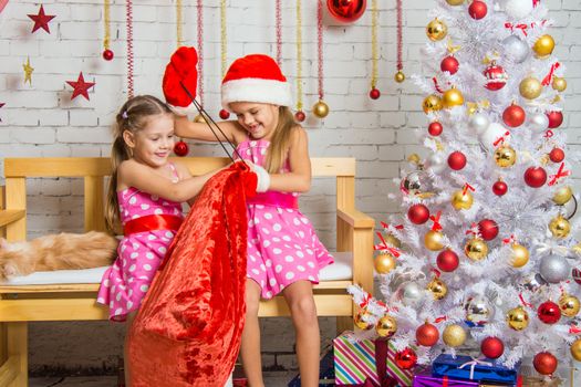 Two funny sisters four girls and six years of playing and having fun in the home New Years interior