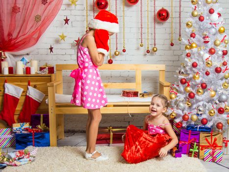 Two funny sisters four girls and six years of playing and having fun in the home New Years interior