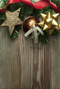Xmas decorations and tree branches over a wooden background