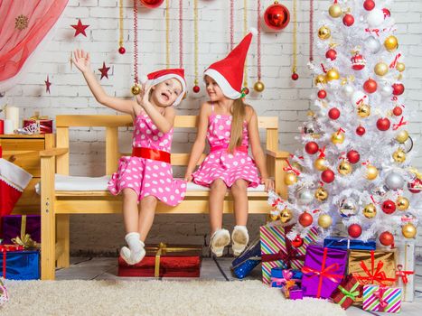Two funny sisters four girls and six years of playing and having fun in the home New Years interior