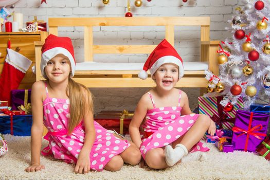 Two funny sisters four girls and six years of playing and having fun in the home New Years interior