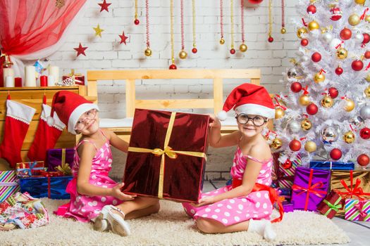 Two funny sisters four girls and six years of playing and having fun in the home New Years interior