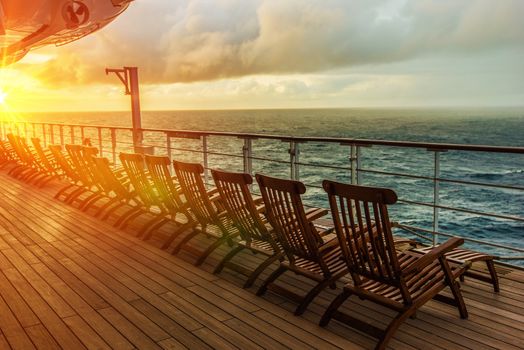 Cruise Ship Wooden Deck Chairs. Cruise Ship Main Deck at Sunset.
