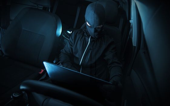 Hacking Car Systems. Hacker with His Computer at Work. 