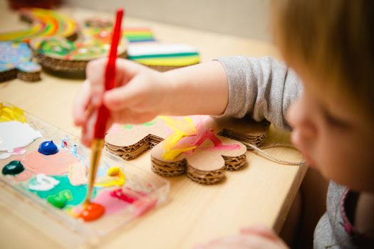 Little female baby painting with colorful paints. selective focus