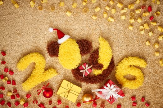 New Year 2016. Christmas.Funny monkey in Santa hat with banana,presents,serpentine. Happy vivid festive still life.Yellow digits handmade. Party decoration, gift box, unusual holiday card, copyspace
