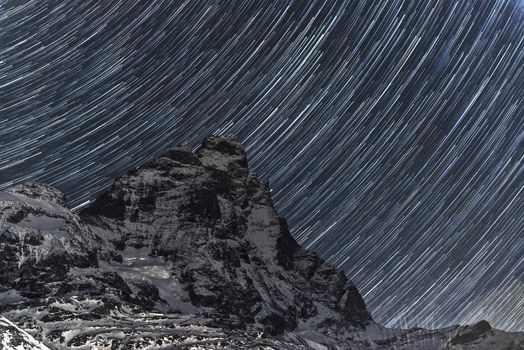 Star trails over Matterhorn in a beautiful autumn night with blue sky background