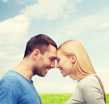 love and family concept - smiling couple looking at each other