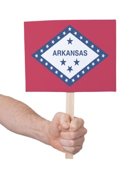 Hand holding small card, isolated on white - Flag of Arkansas