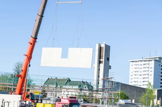 Mobile Crane car on a construction site. Lifts up a concrete wall.