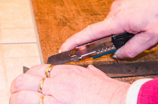 Laying of floor covering. Here, the processing of vinyl laminate floor is shown in the old building. Cut with a utility knife.