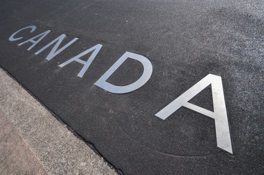 metal lettering CANADA on the pavement on the promenade in front of hotel New York in Rotterdam Holland