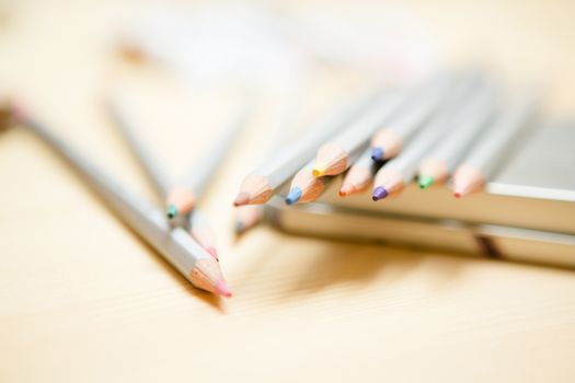 Close up of color pencils with different color over wodden background