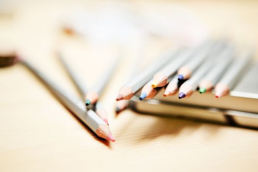 Close up of color pencils with different color over wodden background