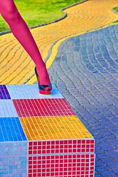 Fashion urban womens sexy legs, pantyhose, stylish heels, people. Vivid shiny multicolored geometry square pattern. Unusual, surrealism abstraction. Girl in trendy shoes, creative mosaic, outdoor
