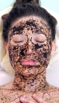 portrait of a girl with eyes closed in a cosmetic mask of coffee