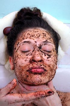 portrait of a girl with eyes closed in a cosmetic mask of coffee