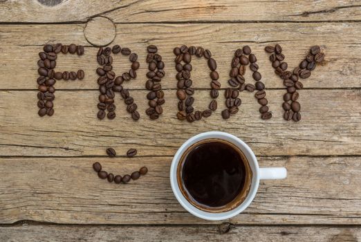 Cup of coffee on wooden background and FRIDAY coffee beans 